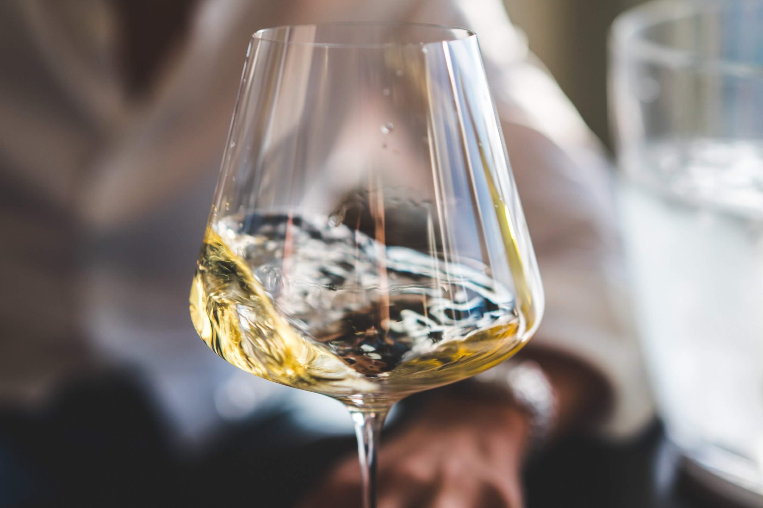 A person holding a glass of a wine