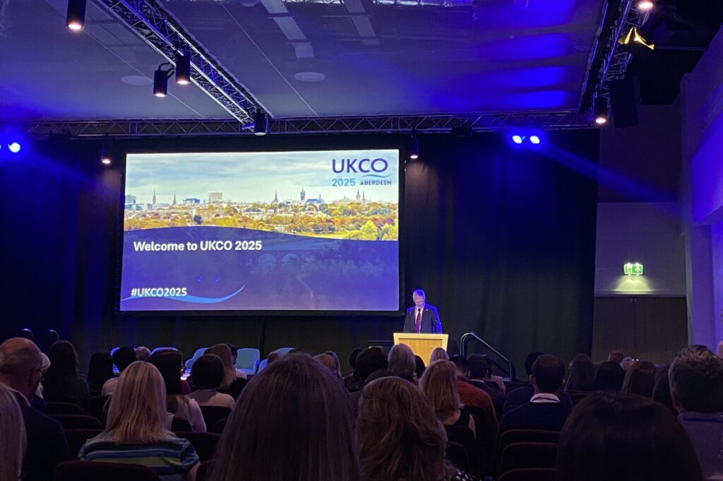 A speaker giving the welcome address at the UKCO 2025 conference in Aberdeen.