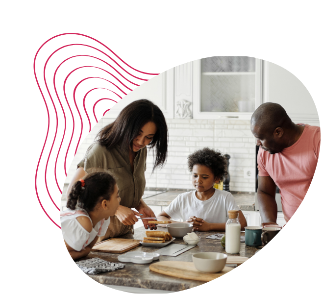 A family in a kitchen, with a woman helping two children prepare food at a counter, and a man standing nearby.