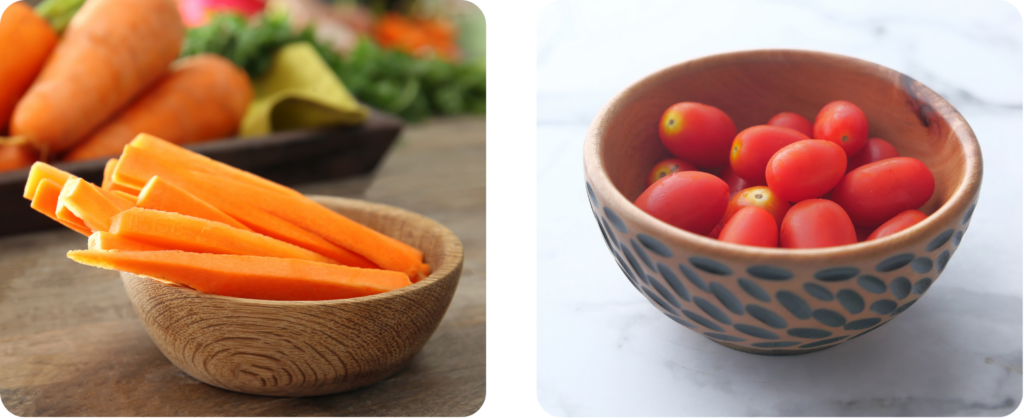 a bowl of carrot sticks and a bowl of plum cherry tomatoes