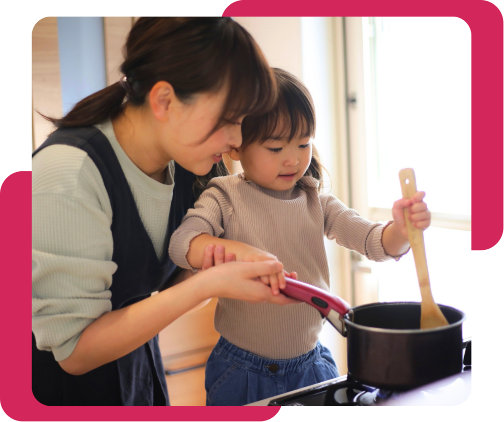 mother and daughter cooking with a pot and wooden spoon