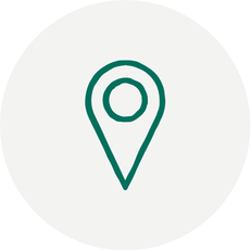 Green outline of a standard map pin location marker on a light grey circle background.